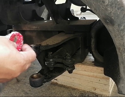 Mechanics changing the steering lower tie rod of a Toyota forklift